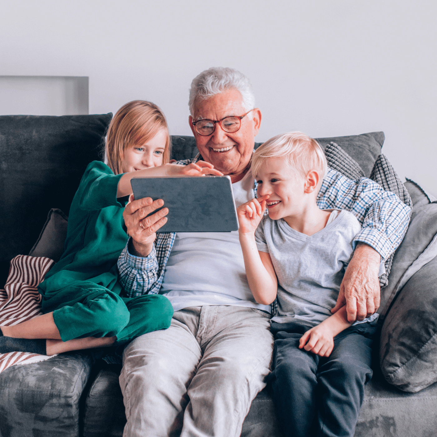 Großvater mit zwei Enkeln und Tablet