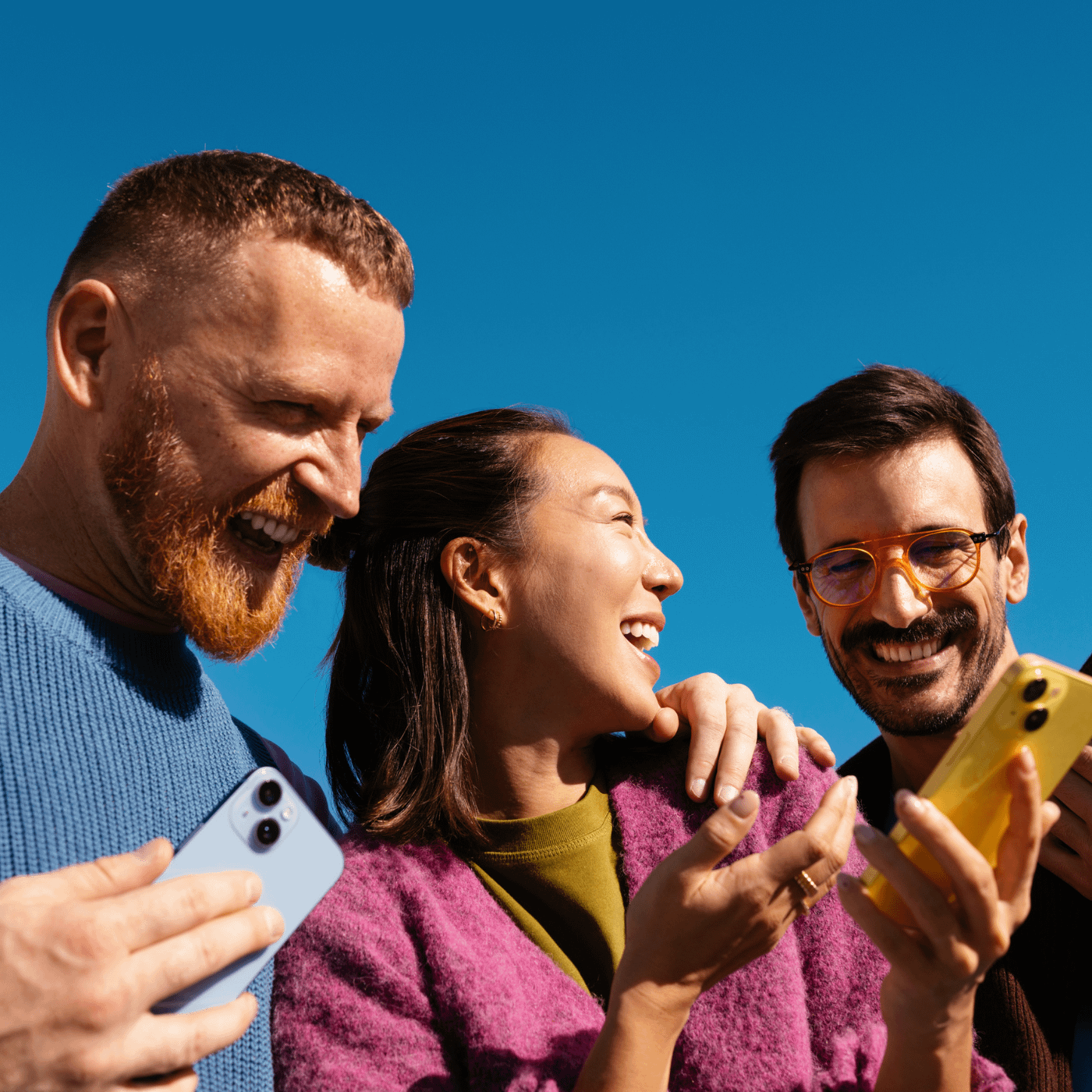 Drei Freunde mit bunten Smartphones